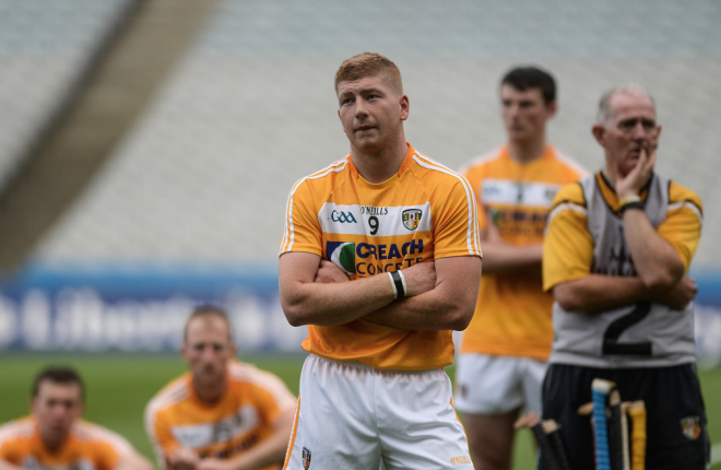 GLUM LOOKS...The antrim players watch Meath collect the Christy Ring Cup